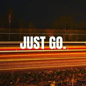 White text reading "JUST GO." overlaid on a nighttime highway with light trails and bare trees in the background