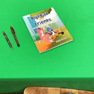 Children's book titled Bluebird and Friends by Arlene Gordon with animated characters on cover, displayed with two red pens on green background