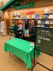 Three adults and a child at a book signing table in a Barnes & Noble bookstore