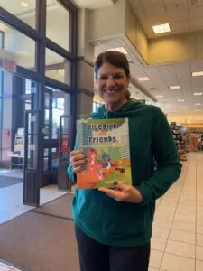 Woman holding children's book in library interior